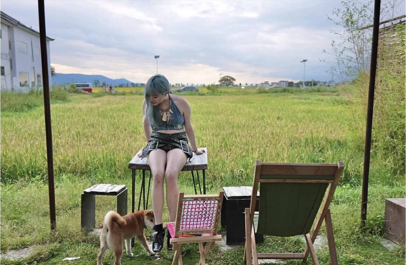 Stella Xu outdoors in a green field with a dog nearby